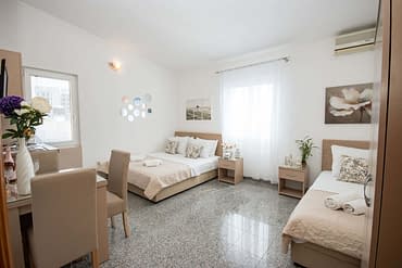 Triple studio apartment with a sea view, double and single bed, and nightstands in Villa Kovacevic